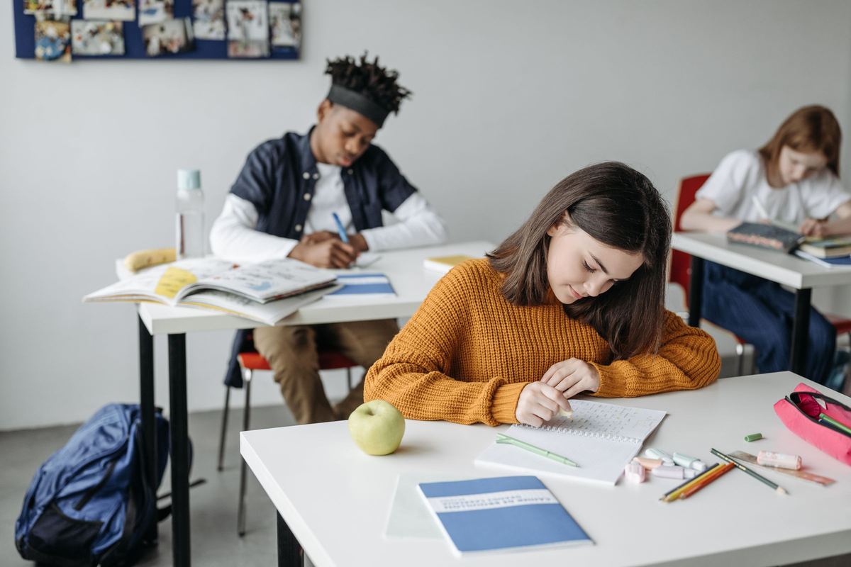Students writing at a shared worktable